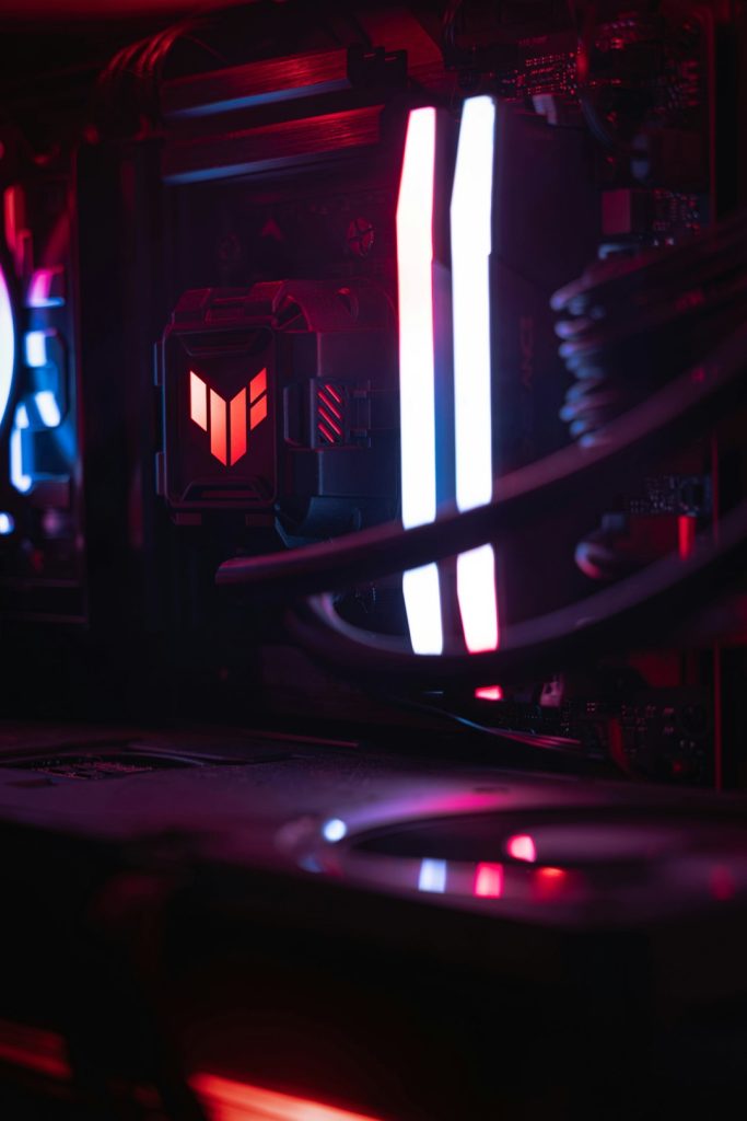 Cinematic macro shot inside a desktop PC, highlighting RGB memory sticks and a water-cooled CPU block.